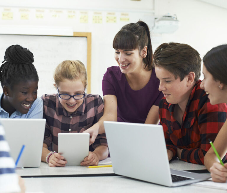 Teenage students with teacher in it class