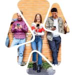 teenagers lean against a wall looking at their smartphones