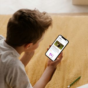 a teen reads the daily juice news articles for teens on his iphone