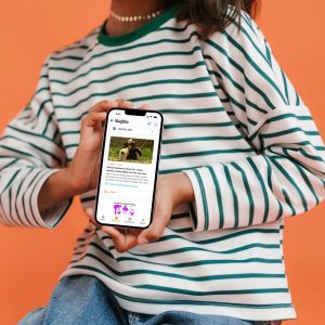 A girl hold a phone displaying The Juice mobile app